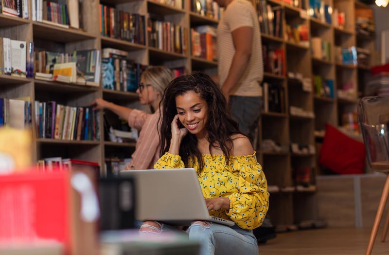 Dissertation study studying in the library on her laptop