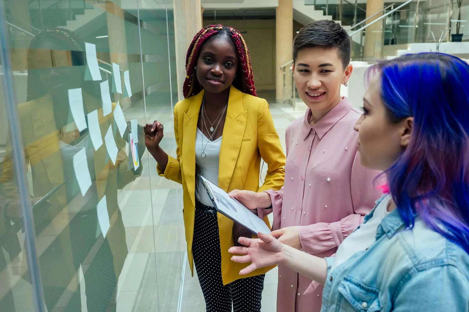 A team of students generating ideas for their dissertation at a planning board on the wall