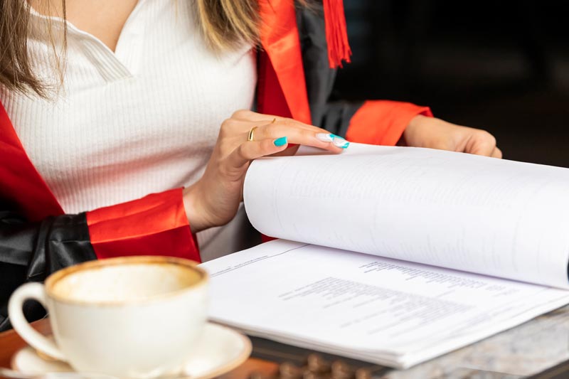 Woman proofreading a dissertation with a cup of coffee